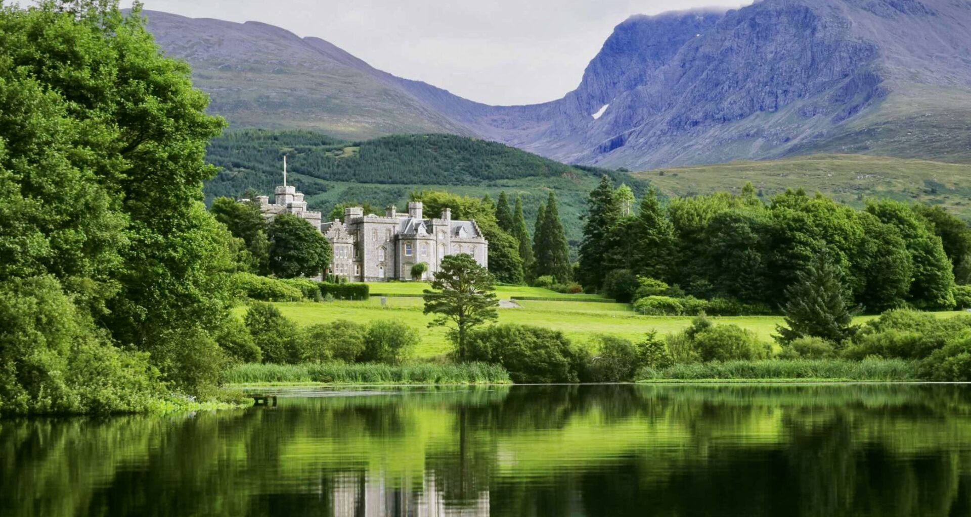 Inverlochy exterior from lake with mountains at one of the best 5-star castle hotels in Scotland