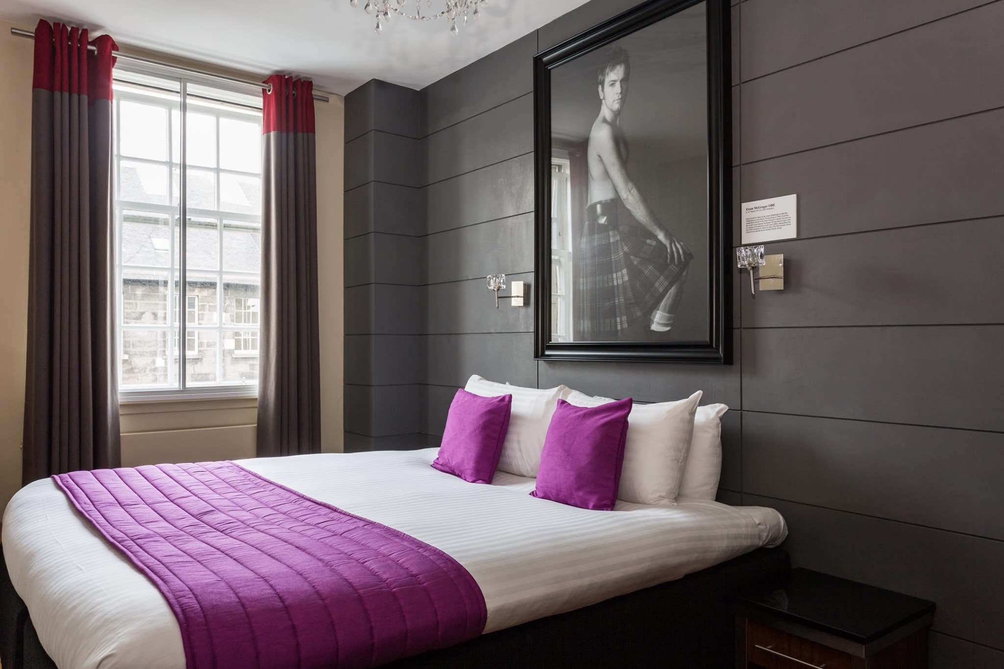 The Angels Share boutique hotel room interior with bed and photo of man in kilt